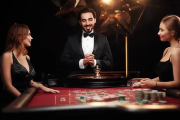 A professional dealer in a tuxedo greeting players at the roulette table, symbolizing the authentic live casino feel at 1777DET.