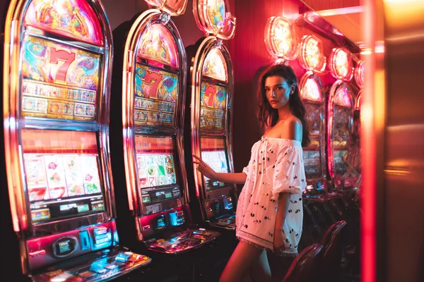 A stylish woman beside vibrant slot machines displaying glowing sevens, showcasing the variety of top slots at 1777DET.
